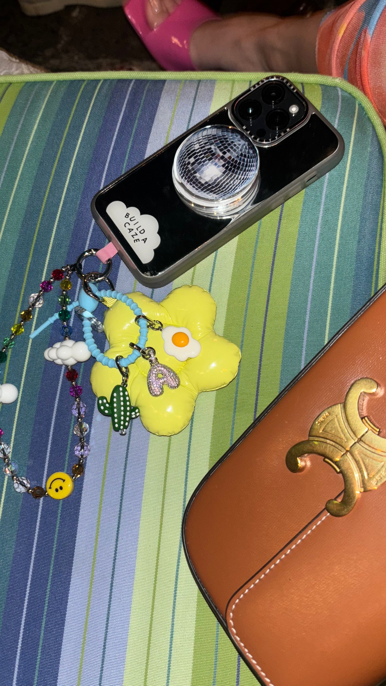 Fried egg phone charm shown in a cluster with a cactus and rhinestone letter charm, Build A Caze.