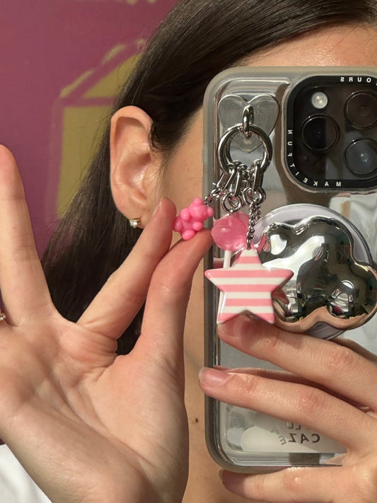 Adorable pink bubblegum bear phone charm with a plush crochet texture and pastel gumball beads, a trendy Y2K aesthetic mobile accessory and decorative tech strap by Build a Caze.