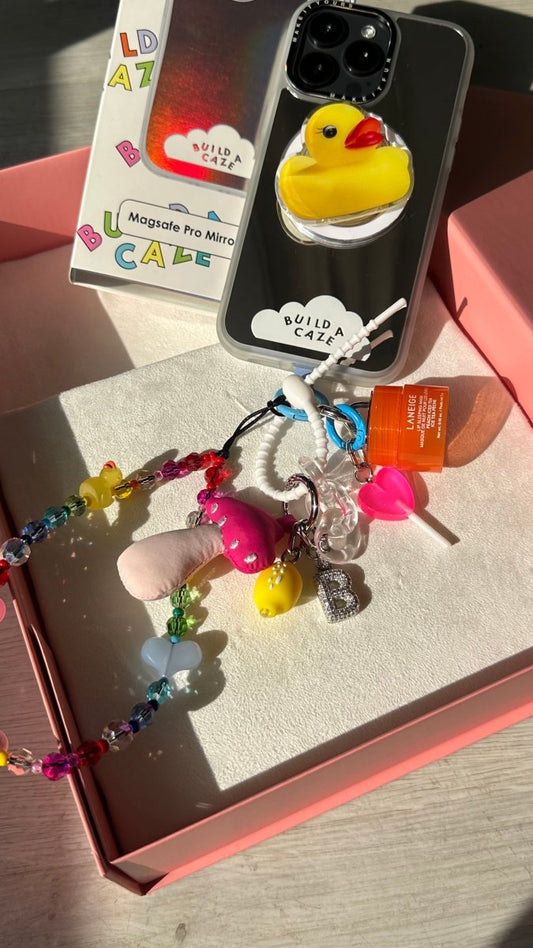 Pink swirl lollipop phone charm with a cute heart detail, nostalgic Y2K aesthetic mobile accessory and decorative tech strap for phone cases by Build a Caze.
