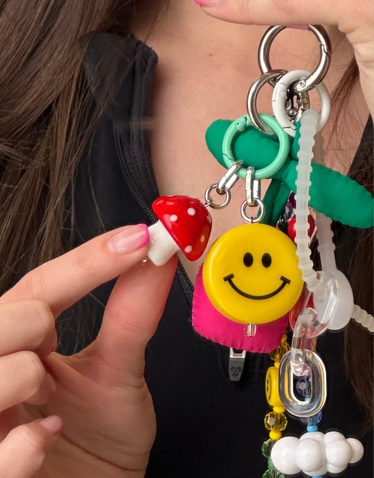 Oversized toadstool mushroom phone charm clipped near a neckline, Build A Caze.