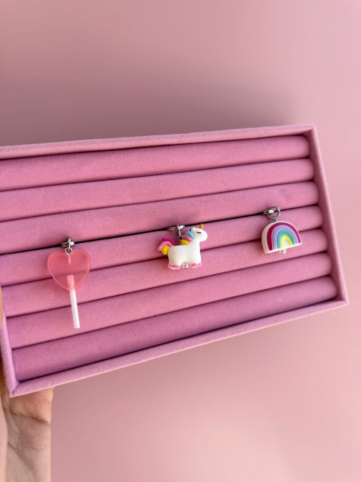Multicolor pastel Candy Uni Spark Charmie charm and dangly accessory shown attached to a phone - Build A Caze