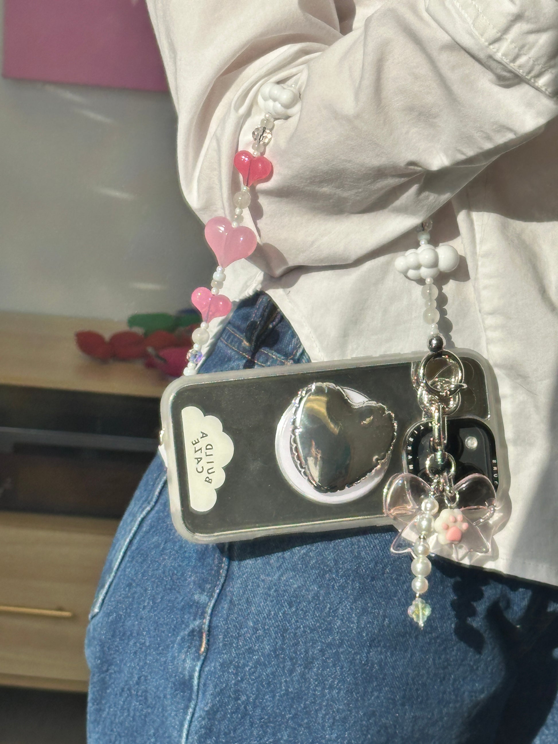 Silver heart pop balloon MagSafe pop holder, metallic silver heart-shaped magnetic pop socket and phone grip accessory.