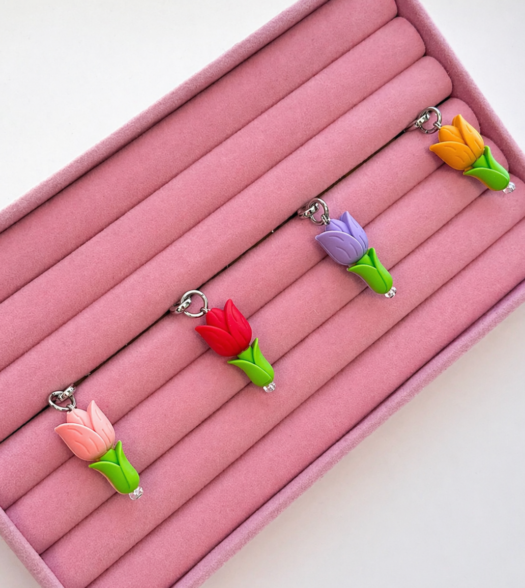 Pink, red, purple, and orange tulip flower phone charms lined up, Build A Caze.