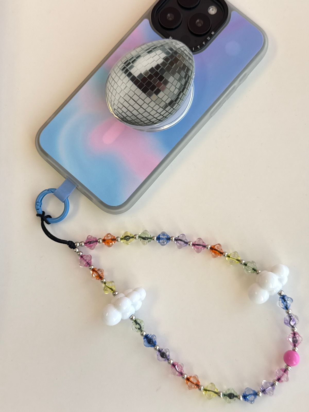 Beaded phone wrist strap featuring translucent colorful rainbow beads, white cloud charms, and a black cord lanyard, perfect as a decorative phone strap and mobile phone accessory.
