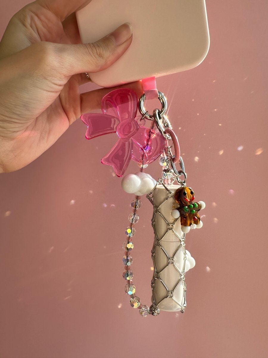 Cute gingerbread man phone charm with a festive holiday design, red and white icing details, and a sturdy wrist strap for Y2K aesthetic mobile phone cases and keychains by Build a Caze.