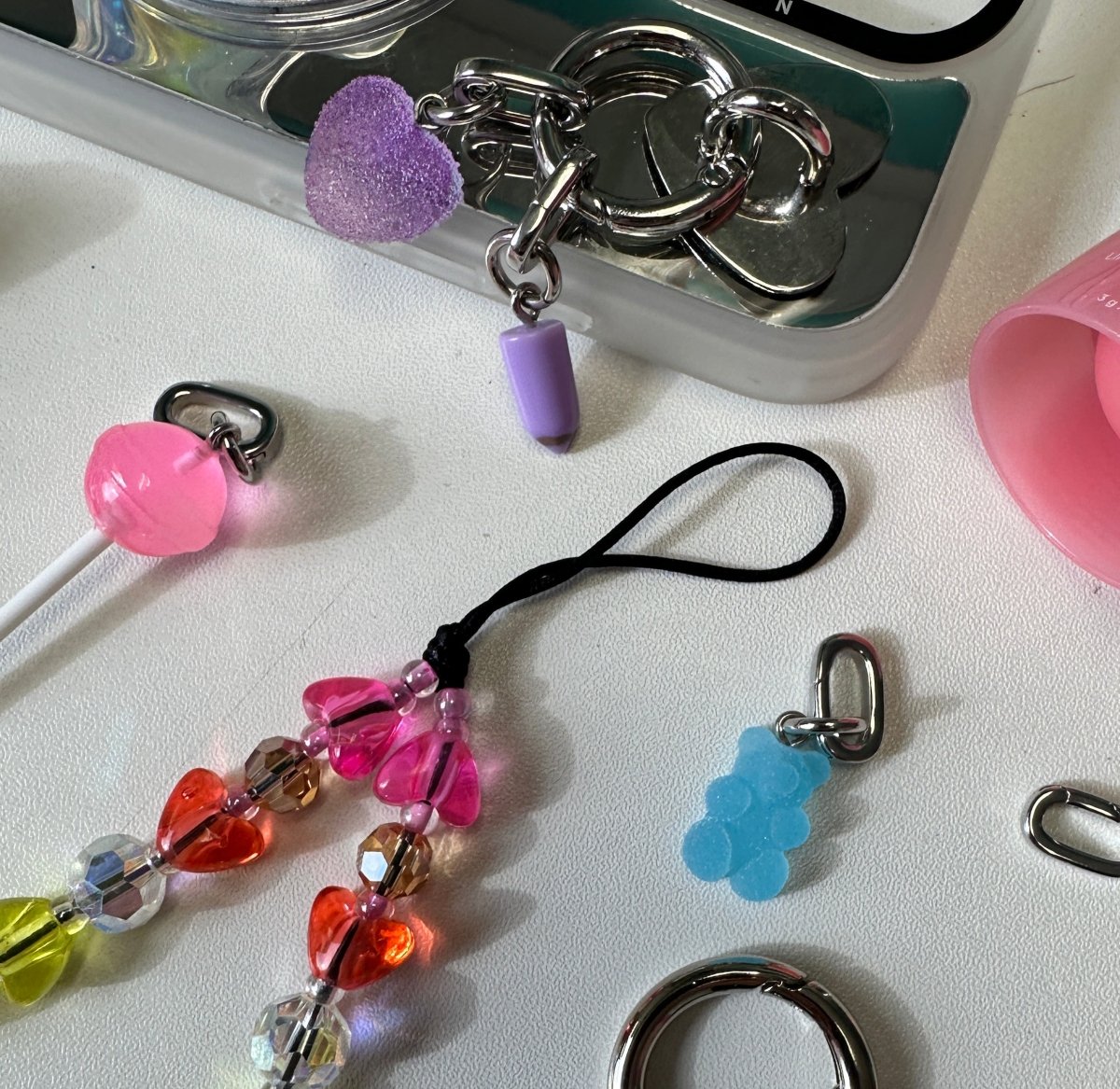 Colorful swirl lollipop phone charm with a sweet candy aesthetic, cute Y2K mobile accessory and decorative tech strap for phone cases by Build a Caze.