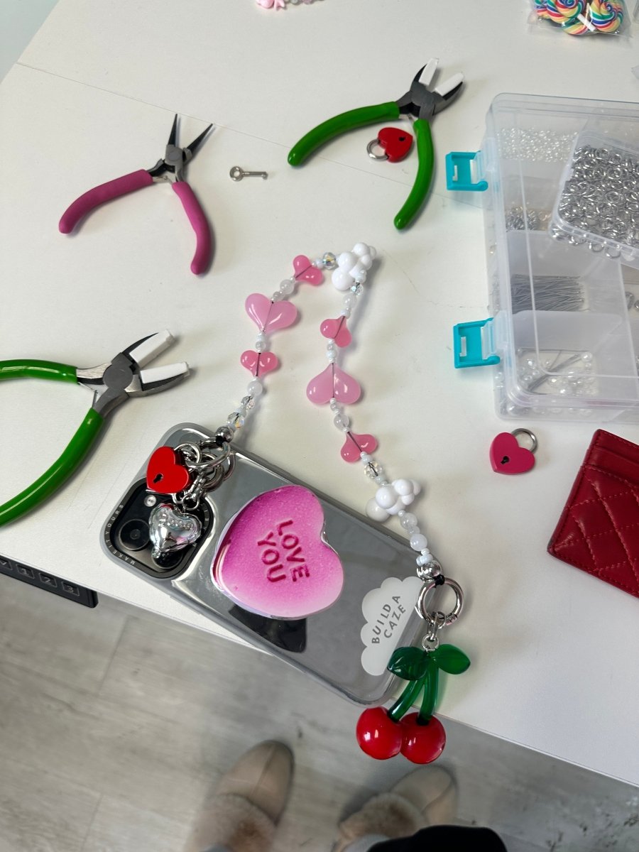 Large 3D red cherry phone charm with a green stem, cute food-themed mobile accessory and Y2K aesthetic tech decoration for phone cases by Build a Caze.