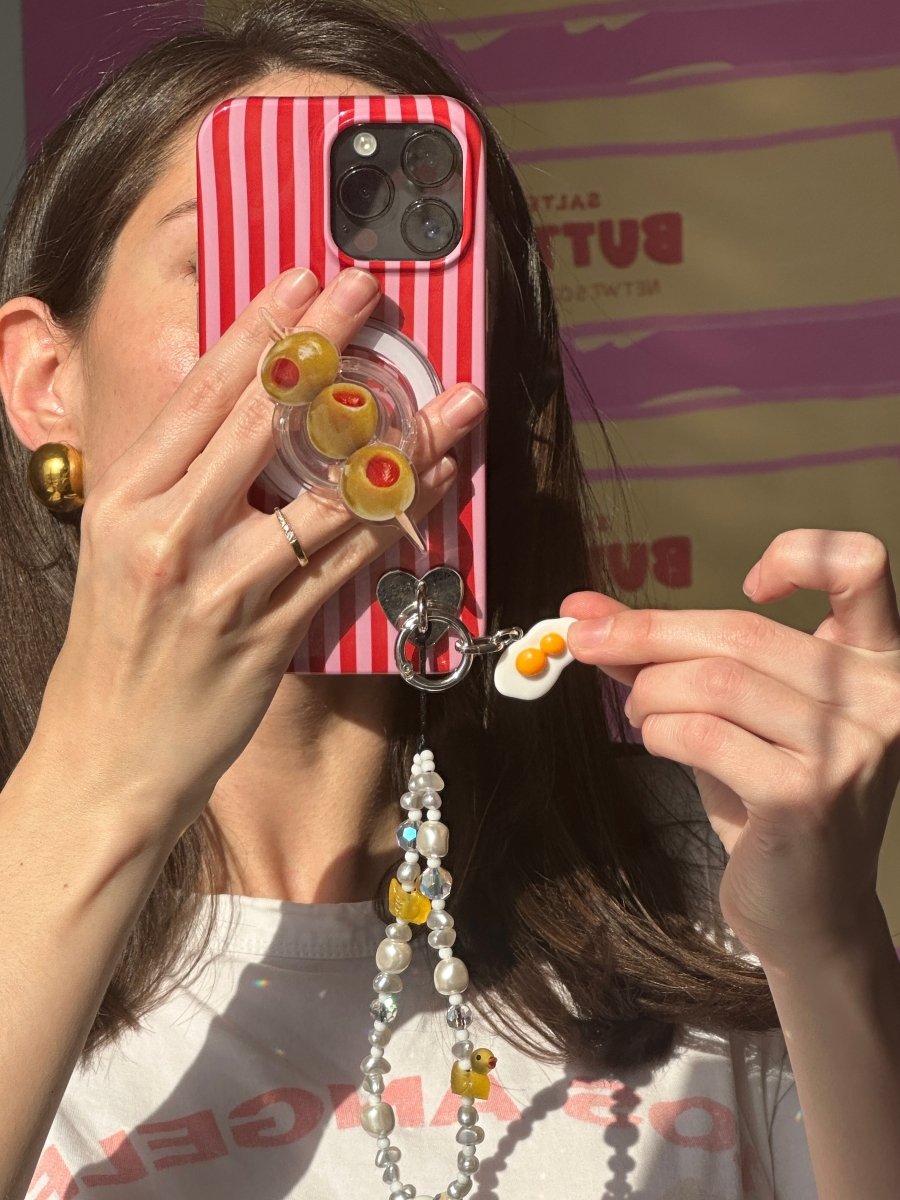 Playful double-yolk fried egg phone charm in a bright sunny-side-up style, cute Y2K aesthetic mobile accessory by Build a Caze.