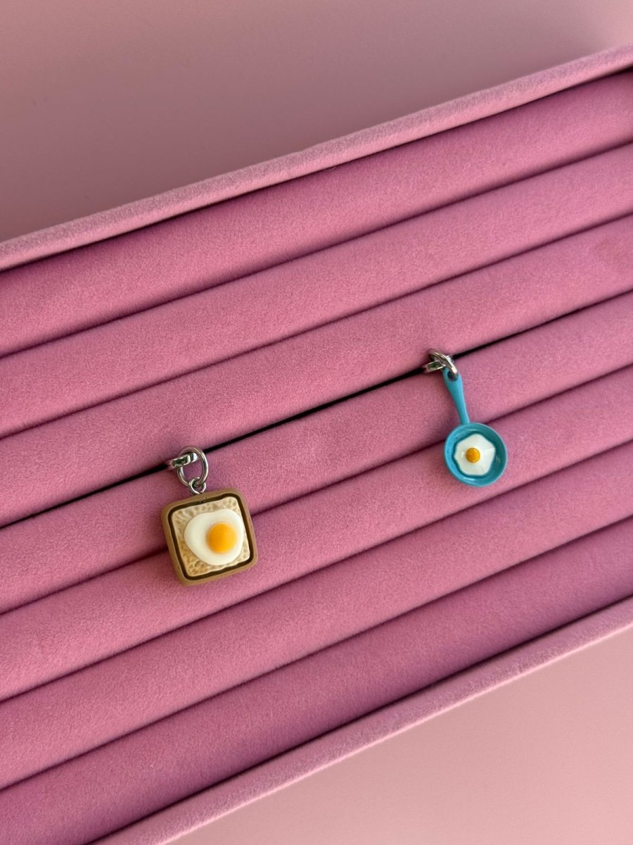 White and brown Eggie Toast Bites Charmie charm and dangly accessory shown from a side angle against a plain background - Build A Caze