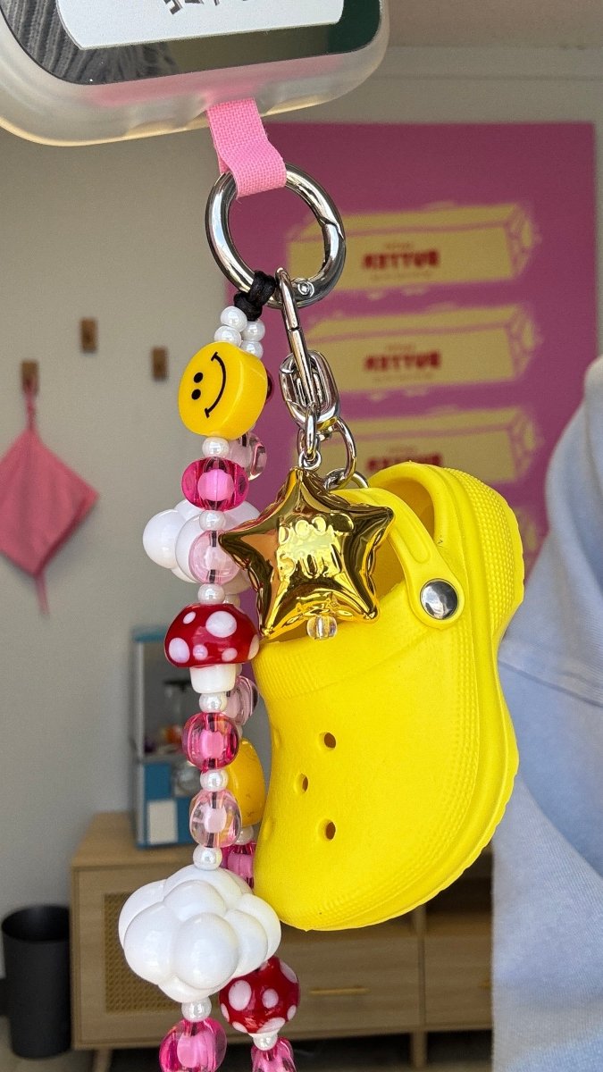 Gold lucky star phone charm featuring a shiny metallic finish, celestial Y2K aesthetic mobile accessory and decorative tech strap by Build a Caze.