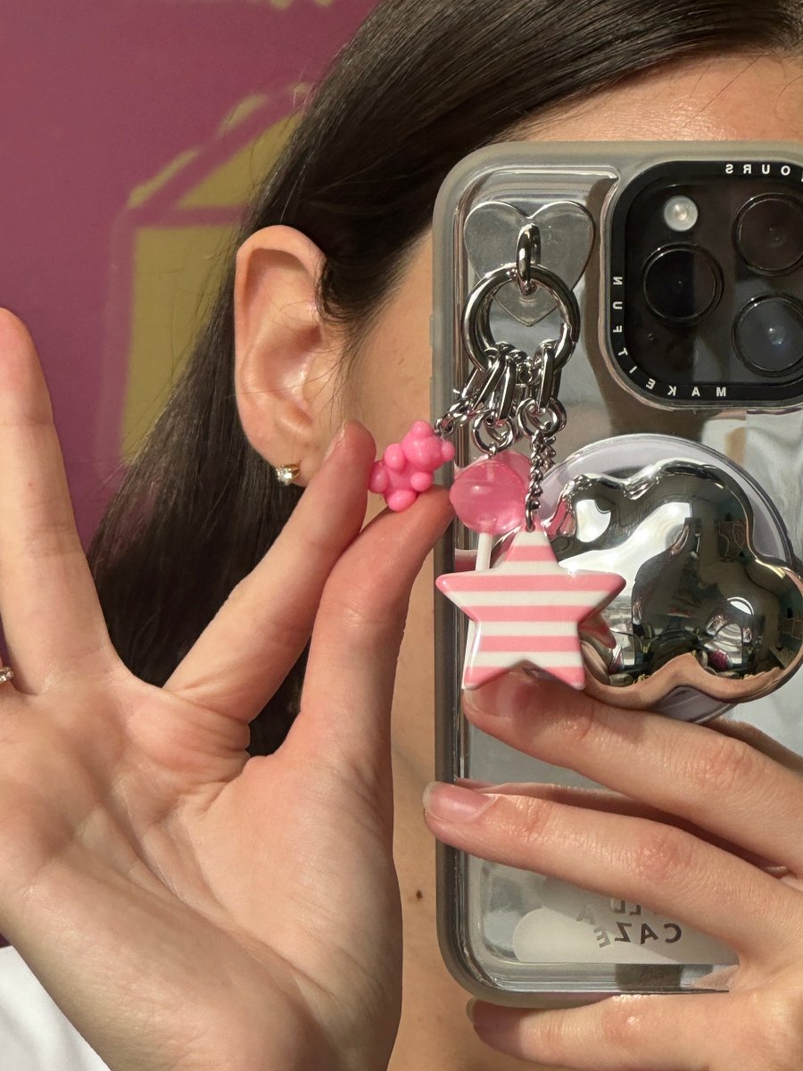 Adorable pink bubblegum bear phone charm with a plush crochet texture and pastel gumball beads, a trendy Y2K aesthetic mobile accessory and decorative tech strap by Build a Caze.