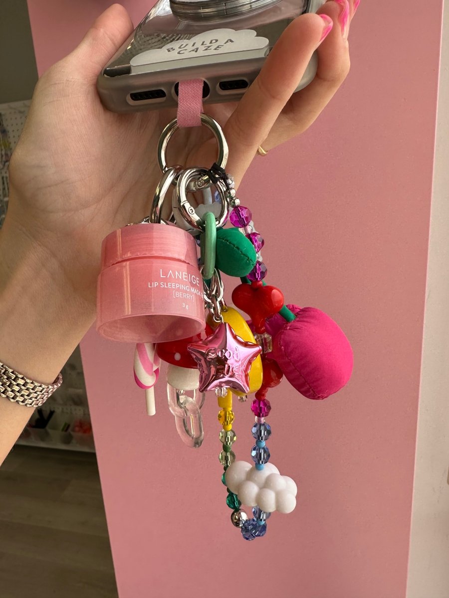 Hot pink Good Luck star charm shown in a mix of BAC charms and lip balms, Build A Caze.