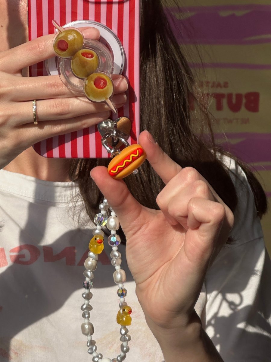 Quirky hot dog phone charm in a mini glizzy style, nostalgic Y2K aesthetic mobile accessory by Build a Caze.