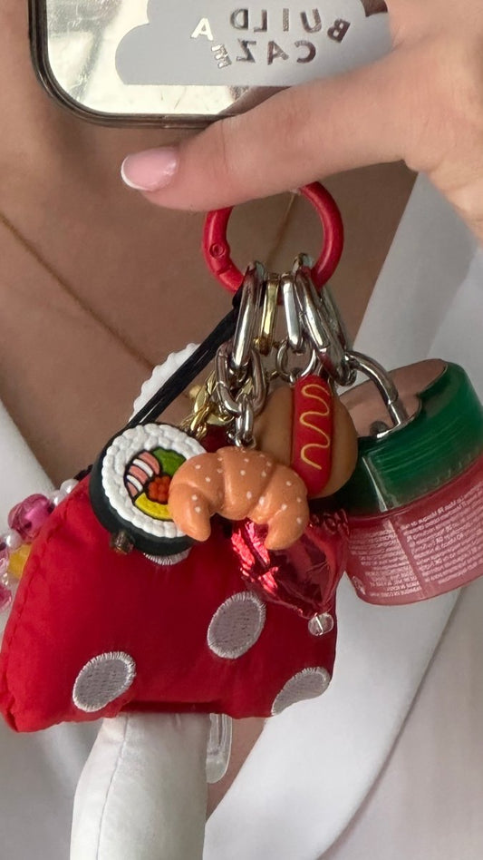 Realistic 3D croissant phone charm featuring a golden-brown pastry design, cute food-themed mobile accessory and Y2K aesthetic tech decoration for phone cases by Build a Caze.