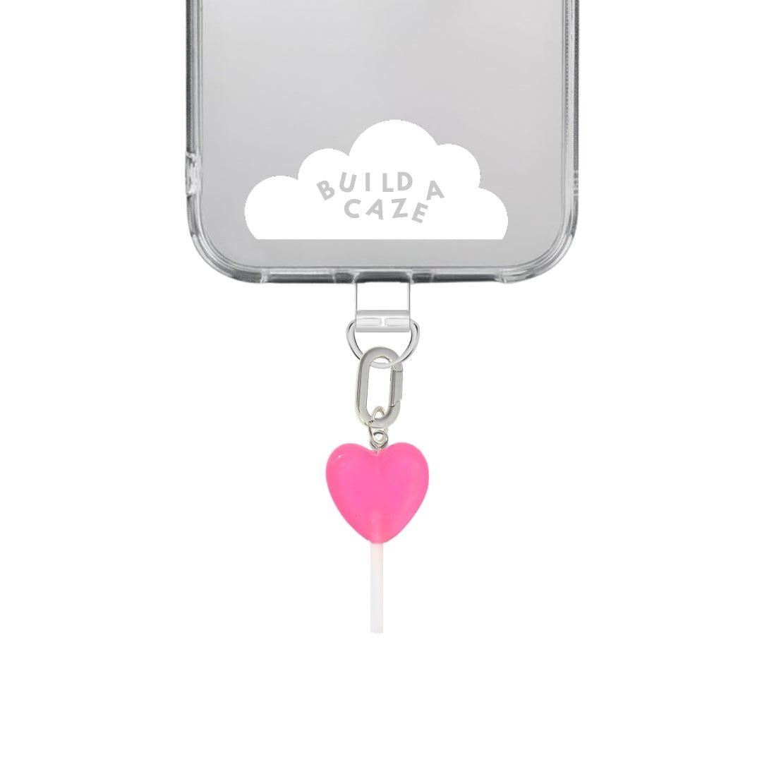 Cute pink heart-shaped lollipop phone charm, sweet Y2K aesthetic mobile accessory and decorative tech strap for phone cases by Build a Caze.