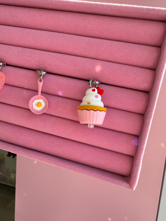 Pink Sunny Side Up Charmie displayed on a pink stand alongside heart and cupcake charmie Build A Caze