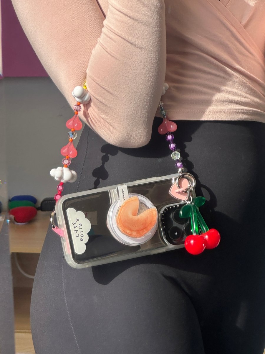 Beaded phone wrist strap featuring pink and multicolor rainbow cloud and heart charms with a black cord lanyard, perfect as a decorative phone strap and mobile phone wrist strap accessory.