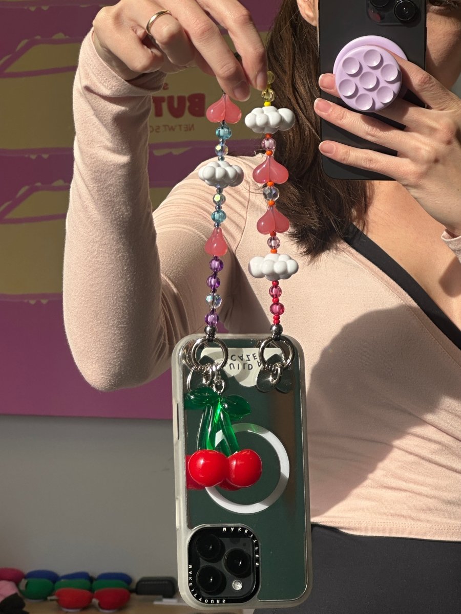 Beaded phone wrist strap featuring colorful rainbow-colored beads and white cloud charms on a black cord lanyard, perfect as a decorative phone strap and mobile phone accessory.