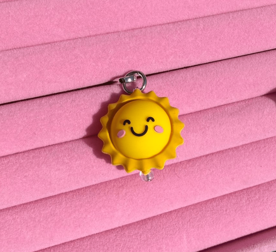 Smiling yellow sun phone charm with blushed cheeks, Build A Caze.