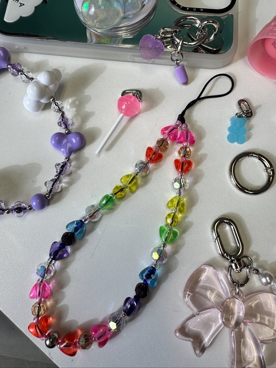 Beaded phone wrist strap featuring charming heart-shaped beads and a black cord lanyard, perfect as a decorative phone strap and mobile phone case accessory.