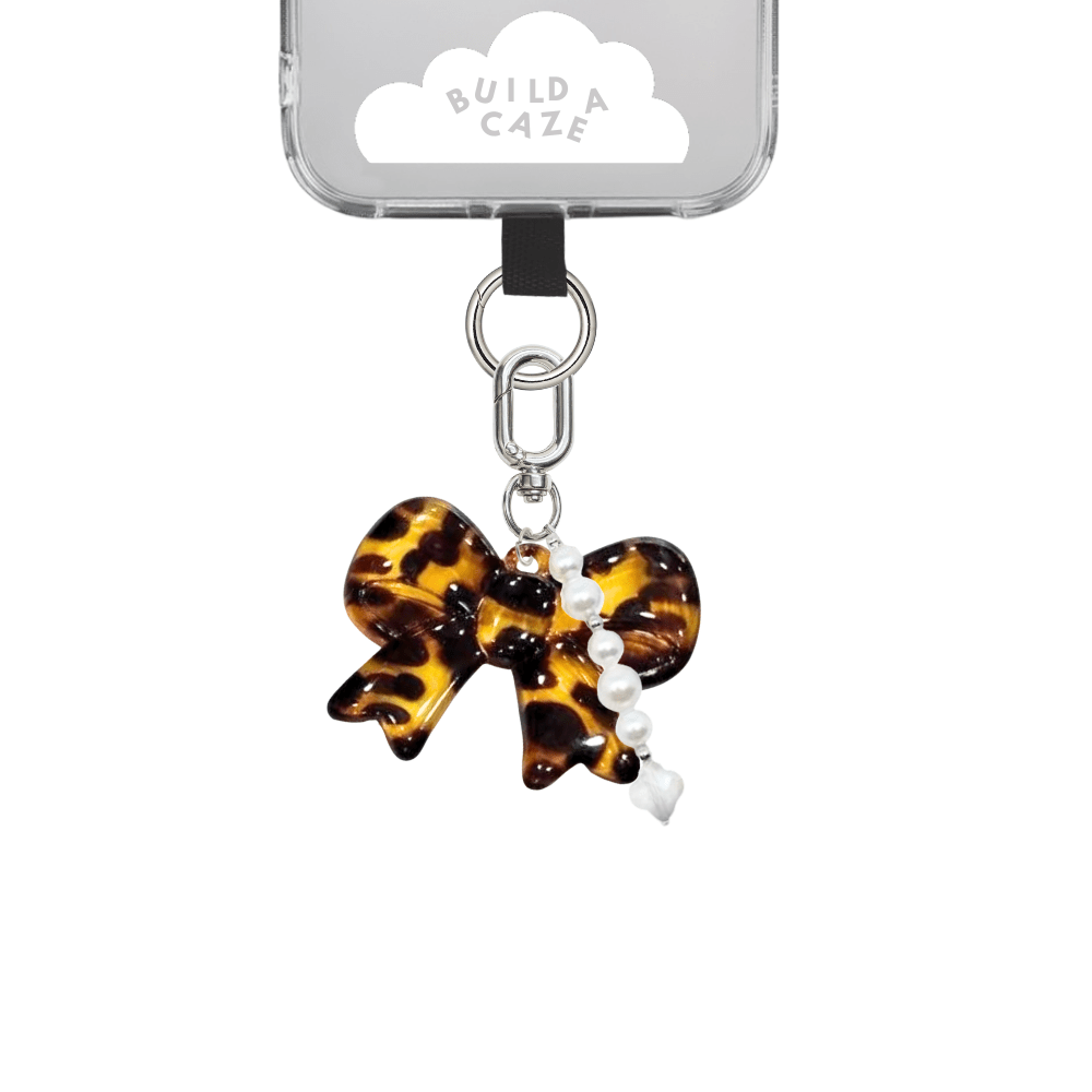 Tortoiseshell Bow U Keychain with dainty pearl string, elegant acrylic bow charm for phone cases and bags, coquette aesthetic mobile accessory, brown and beige patterned keychain attachment.
