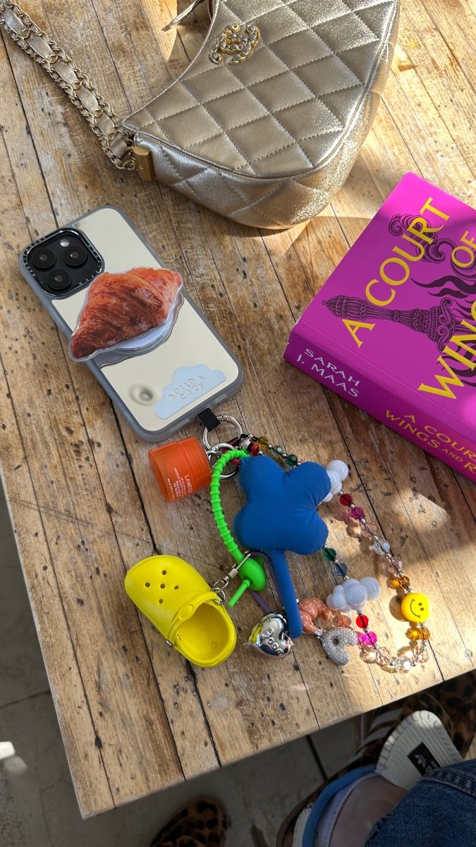 Beaded phone wrist strap featuring vibrant rainbow beads and LOL letter charms with a black cord lanyard, perfect as a colorful phone strap and stylish phone case accessory.